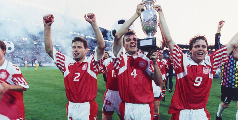 Den 26 juni 1992 chockade Danmark hela fotbollsvärlden genom att vinna Europamästerskapet i fotboll i Sverige genom att i finalen besegra Tyskland med 2-0. Vad som kanske kan anses som mest ironiskt var att Danmark inte ens klarade att kvalificera sig till Europamästerskapen, utan fick en fribiljett då Jugoslavien diskvalificerades på grund av Bosnienkriget, som egentligen skulle ha spelat istället för Danmark. Vi svenskar är inte alls bittra och avundsjuka på denna triumf. Inte alls.
